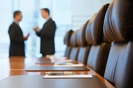 Conference room with two blurred business men in the background.