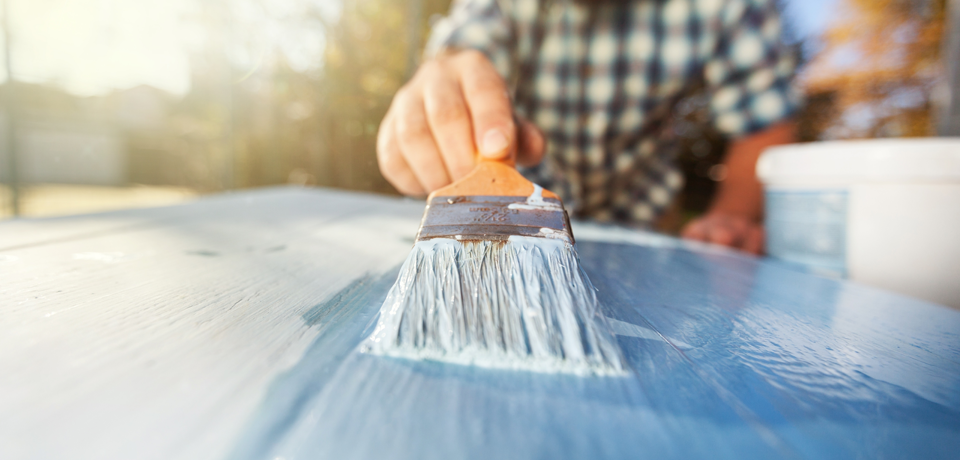 Person Painting Wood with Paint Brush